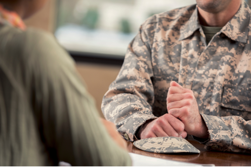 man in camoflage sitting across table from loan officer discussing non-married co-borrower application